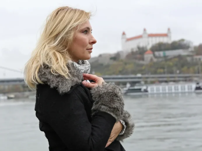 Adriana Tarábková stojící u Dunaje s pohledem na Bratislavský hrad