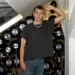 Tomas Sean Pšenička v ležérním oblečení stojí v prostoru s černými vinylovými deskami