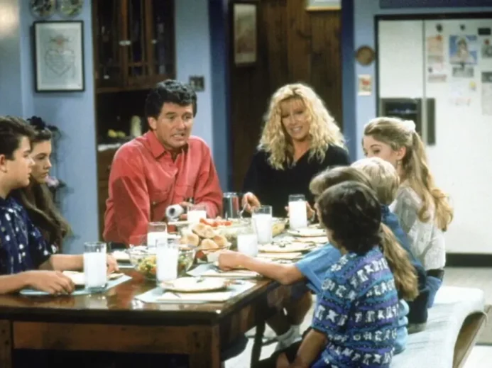 Postavy ze seriálu Krok za krokem sedí kolem stolu v domácí kuchyni