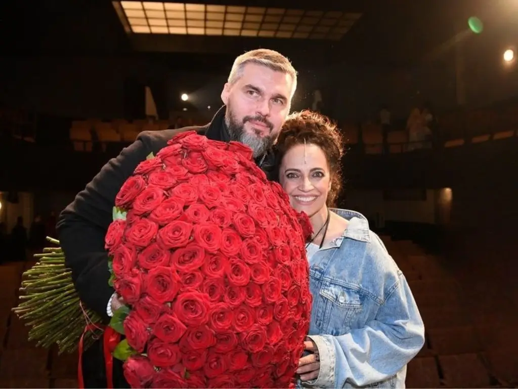 Lucie Bílá se usmívá po boku Radka Filipiho který drží obrovskou kytici červených růží