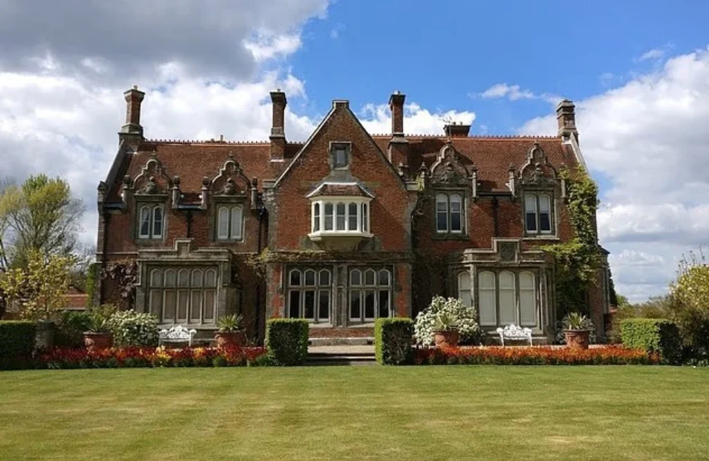 Pohled na rozlehlý cihlový dům ve viktoriánském stylu obklopený zahradou v hrabství Sussex