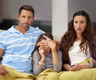 rodiče zakrývají oči dítěti při sledování televize