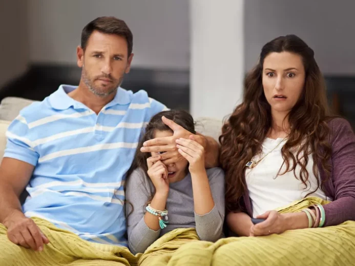 rodiče zakrývají oči dítěti při sledování televize