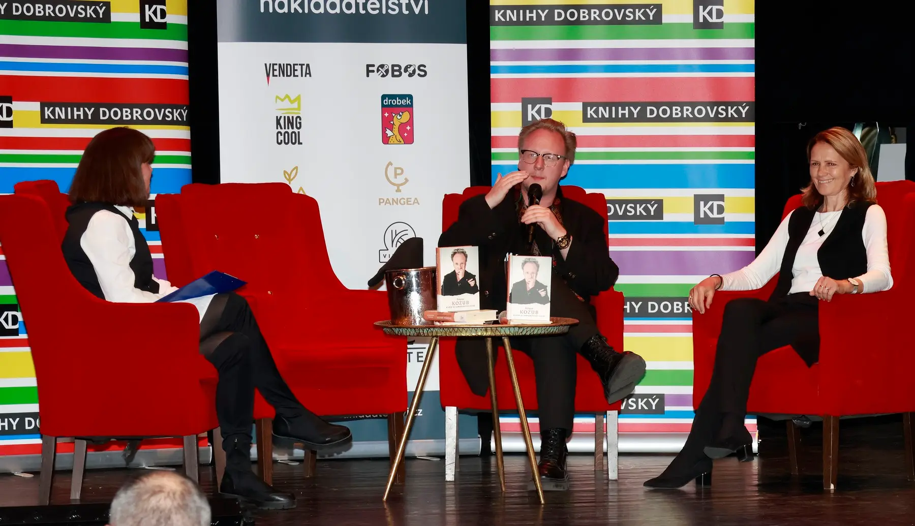 Tři lidé si povídají u stolku