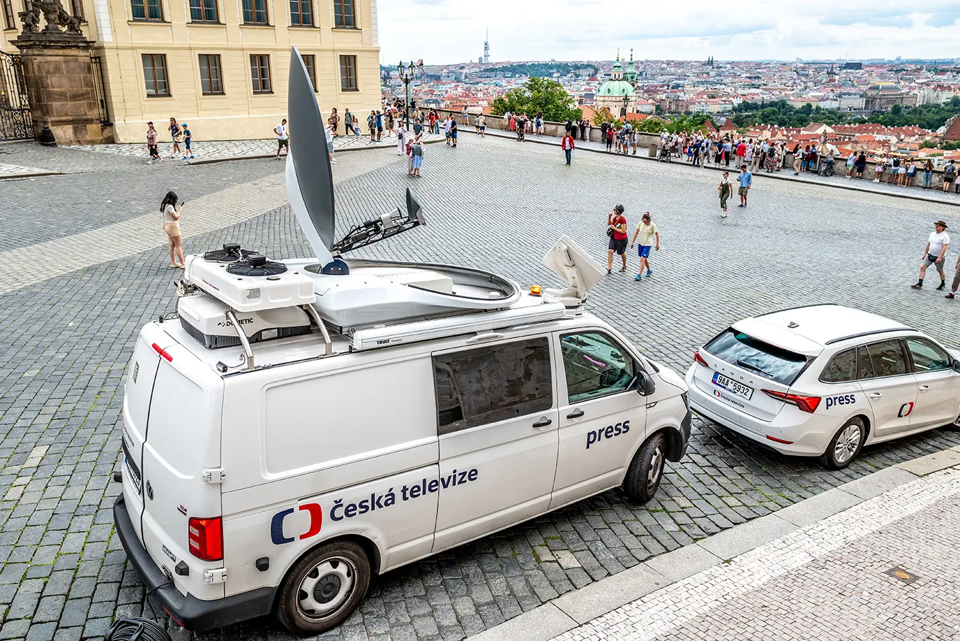 shutterstock_2731344109 - VIPshow Bílá dodávka a menší bílé auto stojí na veřejném prostranství