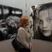 Žena se dívá na výstavě na ženu na fotografii