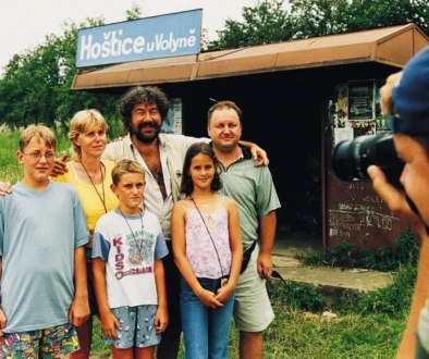 Fotograf fotí skupinu lidí na nádraží