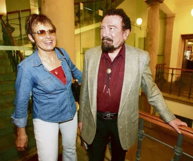 Dva usměvaví lidé ve středním věku, muž je oblečen ve westernovém stylu