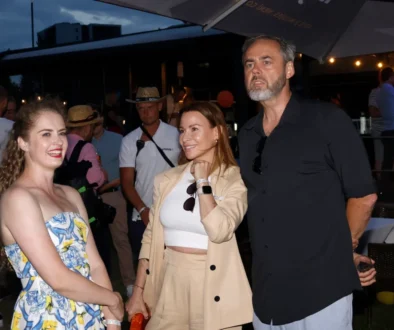 Dvě ženy a starší muž na party, muž se mračí