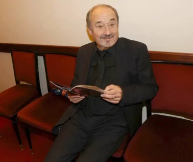 Muž sedí na vínové židli a listuje si časopisem