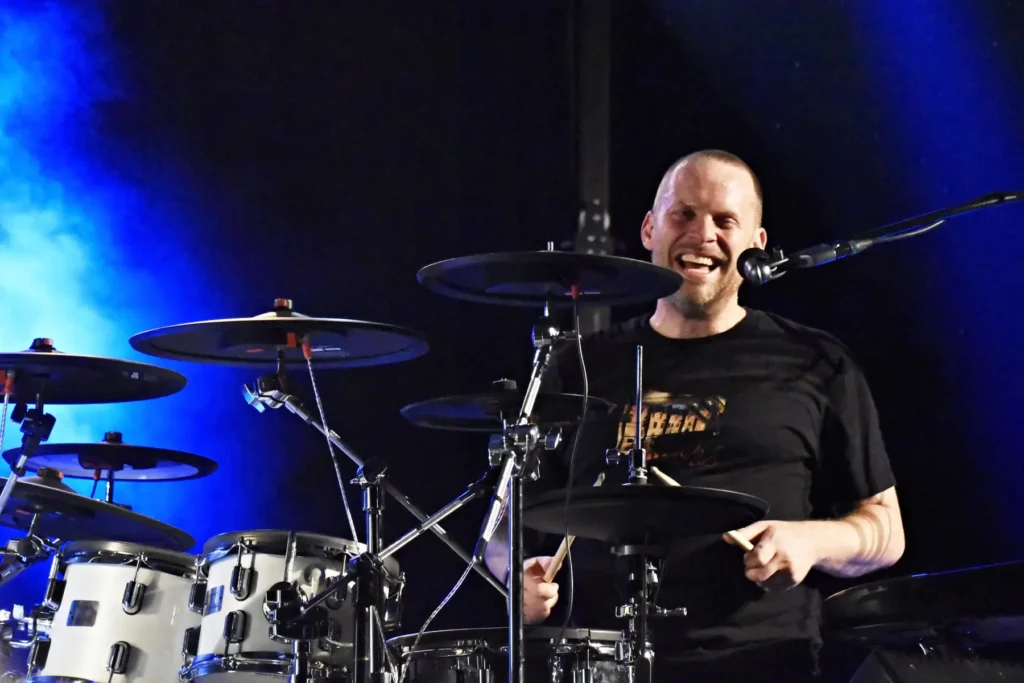 Herec a zpěvák Jakub Prahcař sedí u bicích a zpívá