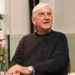 Herec v tmavém svetru sedí a dívá se do strany