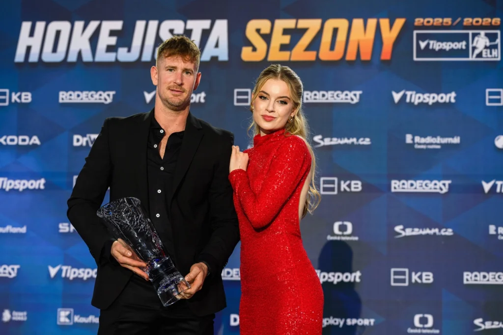 profimedia-1096780783 - VIPshow Muž v černém obleku drží trofej, o něj se opírá žena v rudých šatech