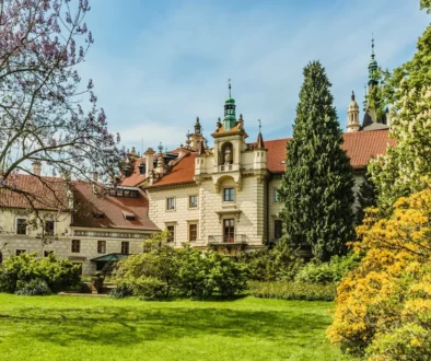 Zámek obklopený zelení za jasného a slunečného dne