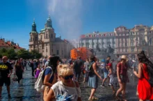 Lidé na náměstí se ochlazují rozprašovanou vodou