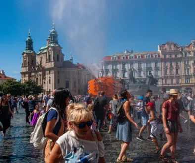 Lidé na náměstí se ochlazují rozprašovanou vodou