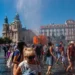 Lidé na náměstí se ochlazují rozprašovanou vodou