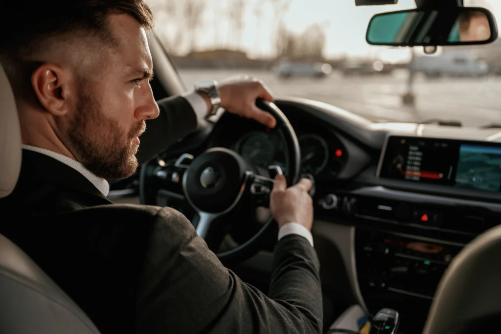 shutterstock_2476677805 - VIPshow Perfektně oblečený a upravený mladý muž řídí luxusní automobil