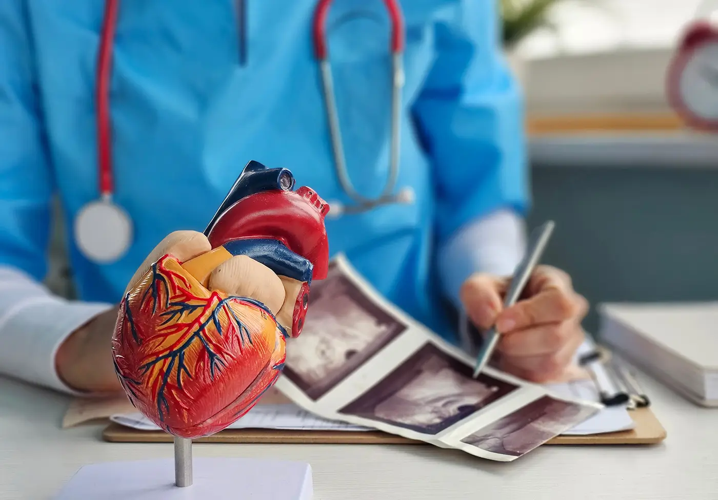 shutterstock_2572022113 - VIPshow Lékař v modrém úboru a se stetoskopem na krku studuje srdce