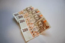 Several 200 Czech koruna banknotes fanned out on a pale surface with portraits visible in the foreground.