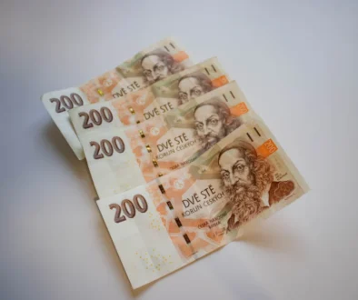 Several 200 Czech koruna banknotes fanned out on a pale surface with portraits visible in the foreground.