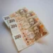 Several 200 Czech koruna banknotes fanned out on a pale surface with portraits visible in the foreground.