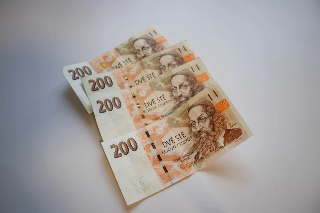 Některé hvězdy ani nevstanou z luxusních polštářů, pokud jim produkce nenabídne závratný honorář. - VIPshow Several 200 Czech koruna banknotes fanned out on a pale surface with portraits visible in the foreground.