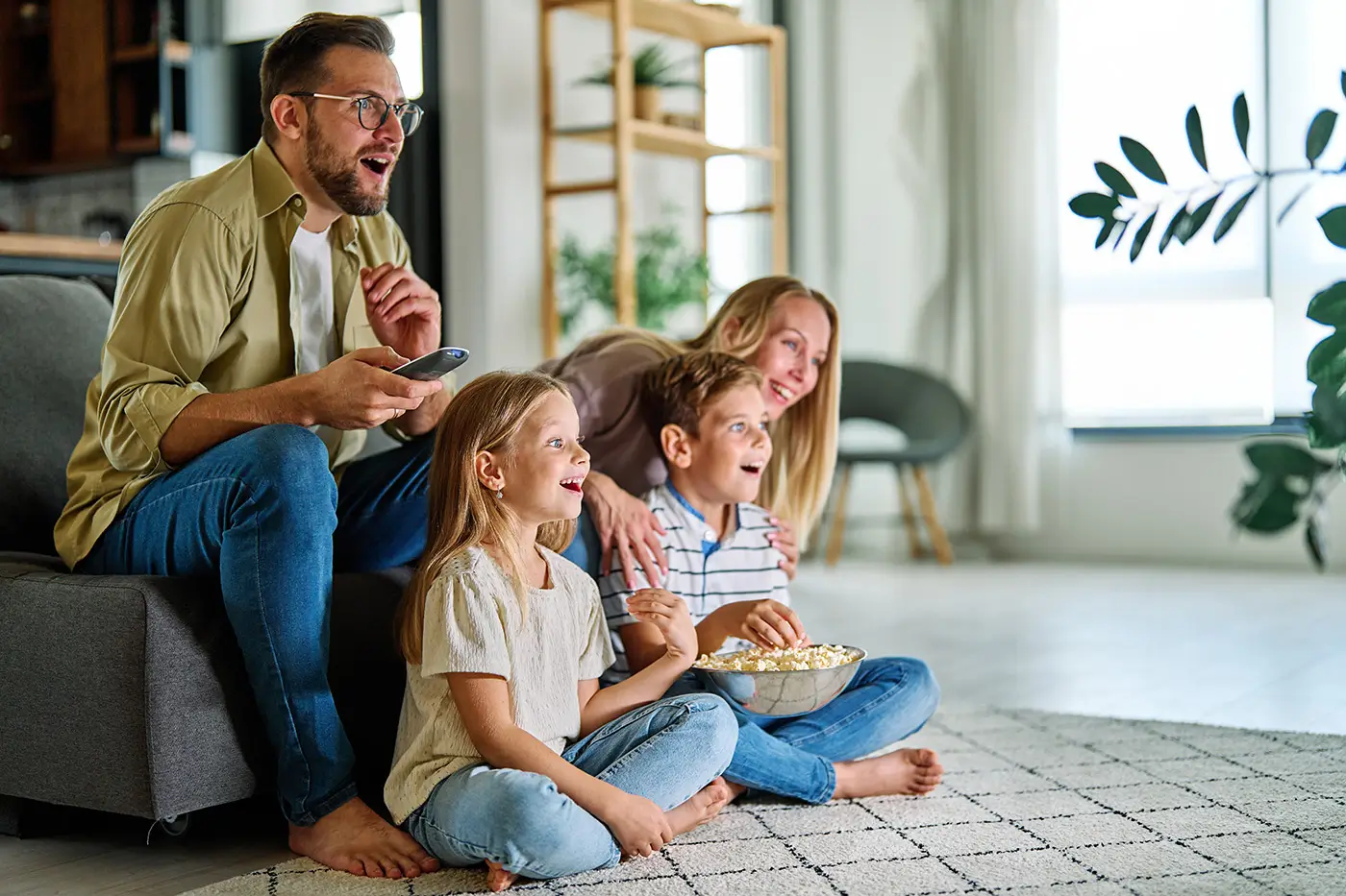 shutterstock_2754794489 - VIPshow Matka, otec a jejich děti společně sedí v obývacím pokoji a sledují televizi