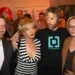 Dva muži a dvě ženy se společně objímají a usmívají se