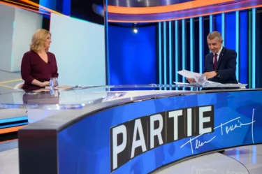 Žena a muž naproti sobě sedí ve studiu a debatují