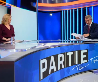 Žena a muž naproti sobě sedí ve studiu a debatují