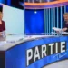Žena a muž naproti sobě sedí ve studiu a debatují