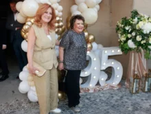 Dvě ženy se fotí před číslem devadesát pět a před nafouknutými balonky