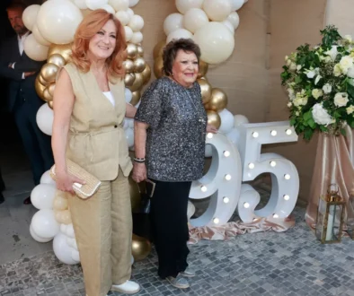 Dvě ženy se fotí před číslem devadesát pět a před nafouknutými balonky