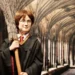Vosková figurína připomínající známého Harryho Pottera, má kouzelnický hábit, koště a kulaté brýle