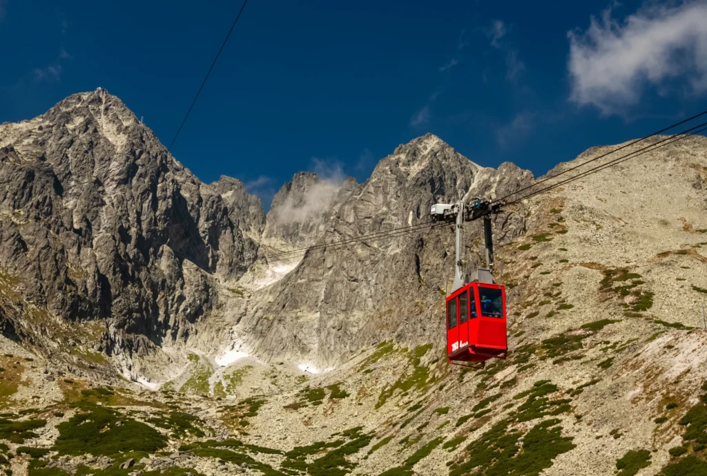 shutterstock_2296500253 - VIPshow Lanovka na Lomnický Štít, Červená kabina se vznáší pod vrcholky velehor