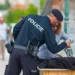 Muž v policejním oblečení kontroluje ženě tašku