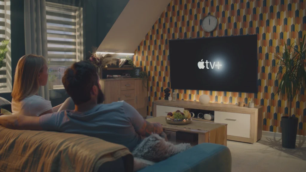 Dva lidé se v obýváku dívají na televizi
