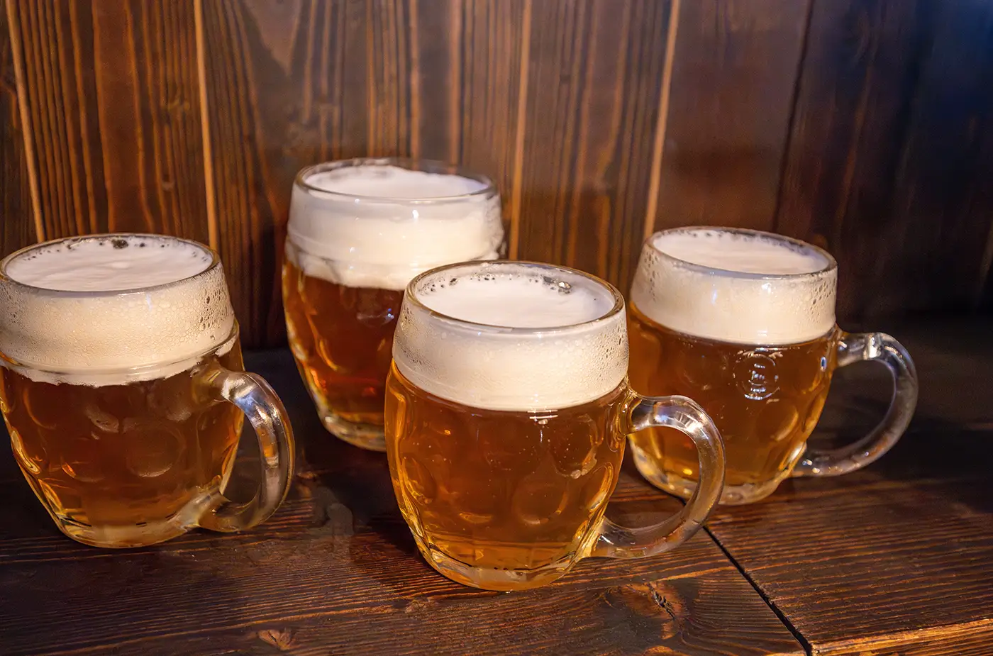 shutterstock_2660069507 - VIPshow Na stole stojí čtyři půllitry s pivem