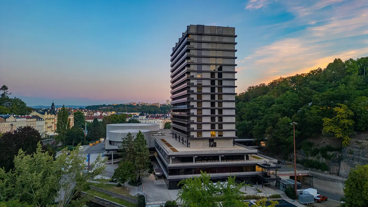Panoramatický pohled na vysoký hotel uprostřed města a nedaleko lesa