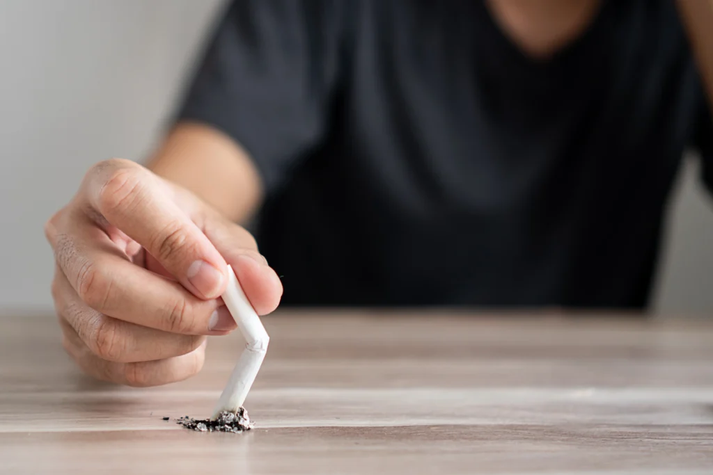 Muž láme o stůl cigaretu, nevykouřenou