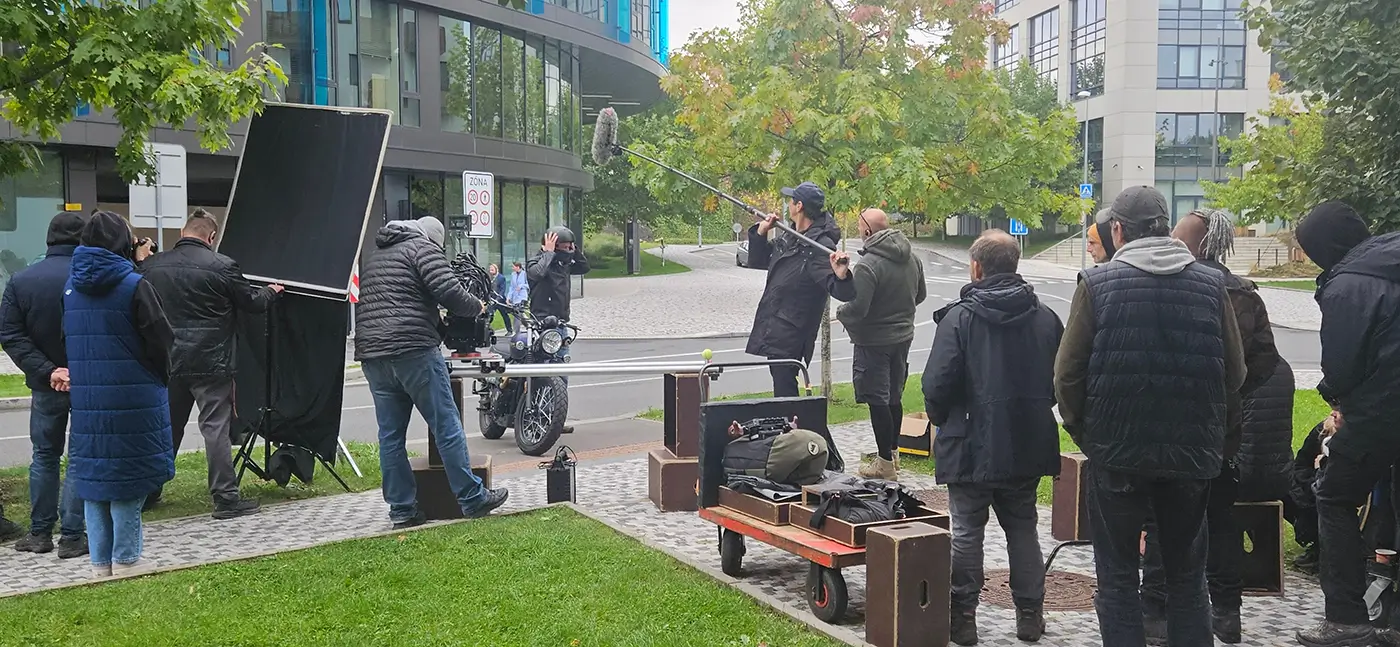 Na veřejném prostranství se pohybuje filmový štáb a něco natáčí