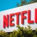 Logo Netflixu na billboardu obklopeného zelenými keři