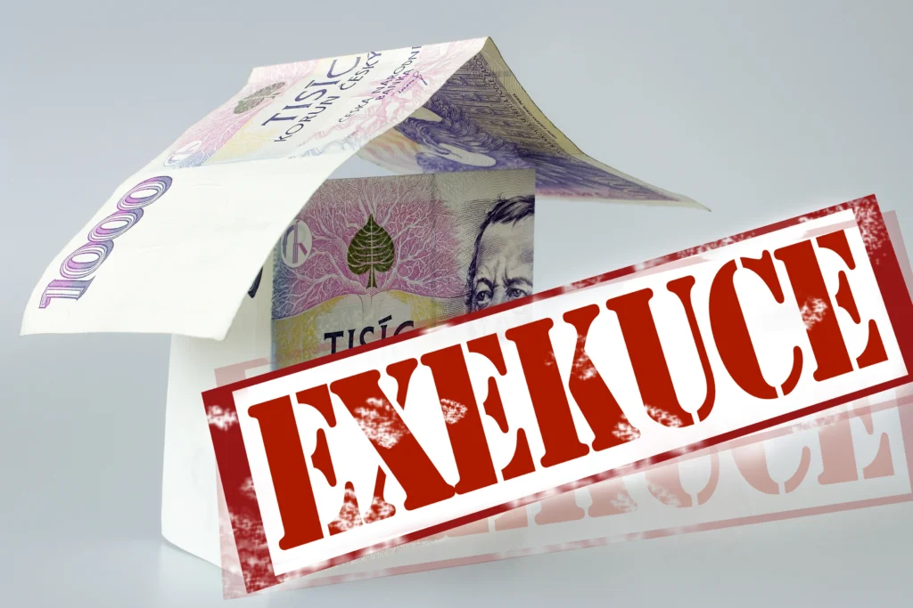 Domeček postavený z tisícových bankovek a přes ně razítko Exekuce