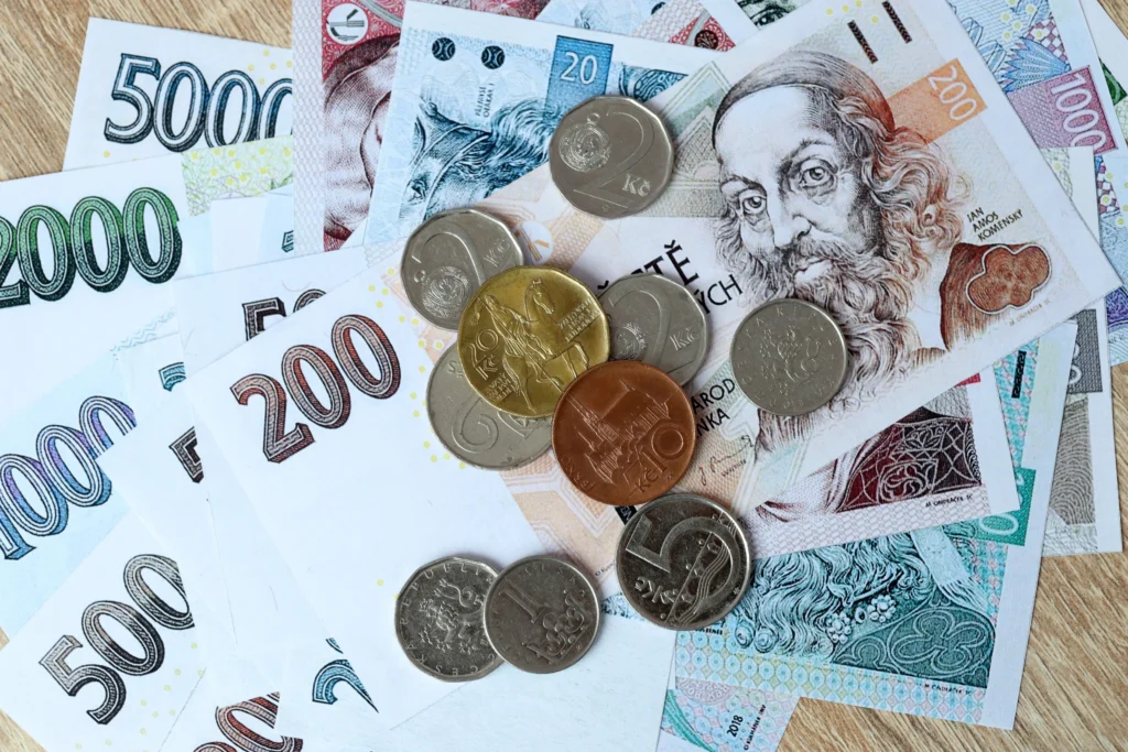 shutterstock_2793301299 - VIPshow Paníze, české koruny, na jedné hromadě na stole leží papírové bankovky a kovové mince