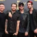 Skupina čtyř vysmátých mužů před stěnou s nápisy MTV
