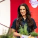 Žena s dlouhými tmavými vlasy se dívá z jejího pohledu doprava a před ní stojí rozmarýn