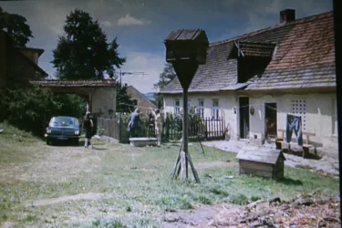Stará chalupa a dvorek s auty na české vesnici, kde se zrovna natáčí film