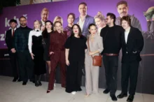 Skupina lidí ve večerních šatech před plátnem, na které jsou také oni, ale ve filmu