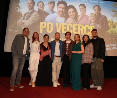 Skupina lidí stoji na podiu pod filmovým plátnem